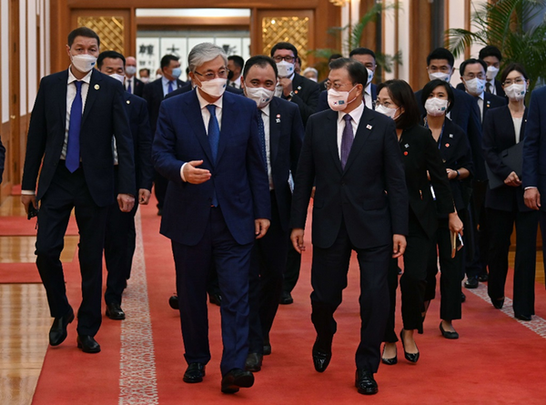 President Moon Jae-in (right, foreground) and President Kassym-Jomart Tokayev of Kazakhstan (left, foreground) walk toward a conference room at Cheong Wa Dae for the summit meeting on Aug. 17, 2021.