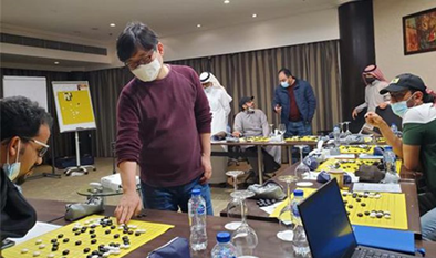 Kim Myung-wan (standing, 8th dan in Baduk) plays a multifaceted game for aspiring Baduk (Go) leaders in Saudi Arabia.