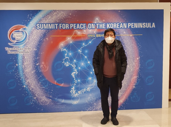 Vice Chairman Song Na-ra of The Korea Post takes a picture in front of the poster for the summit for peace on the Korean Peninsula.