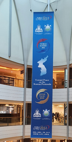 A large placard announcing the 2022 summit for peace on the Korean Peninsula and other events