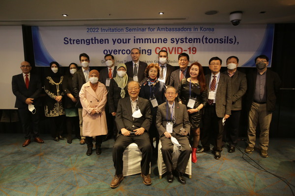 Director Seo Hyo-seok of Pyunkang Korean Medicine Hospital and Chairman Lee Kyung-sik of The Korea Post media (seated, left and right, respectively) pose with the ambassadors, other guests.