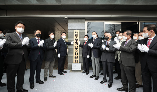 President-elect Yoon Suk-yeol (fourth from left) and Chairman Ahn Cheol-soo of the 20th Presidential Transition Committee (fifth from left) hold a signboard of the committee in Tongui-dong, Jongno-gu, Seoul on March 18.