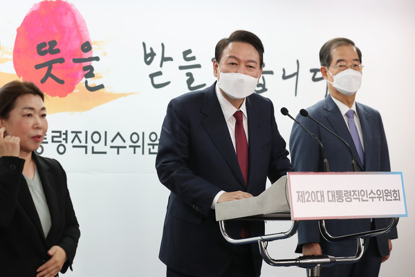President-elect Yoon Suk-yeol (center) announces the appointment of former Prime Minister Han Duck-soo (right) as the nominee for his first prime minister at the briefing room of the 20th Presidential Transition Committee in Tongui-dong, Seoul on April 3, 2022.