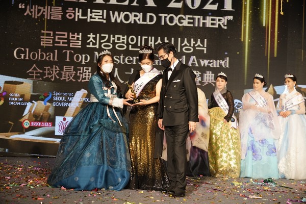CEO Park Myung-sook (left) receives a trophy at the Global Top Master Award Ceremony.