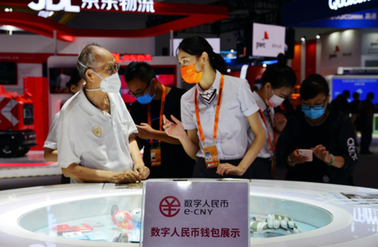 A staff member with the Bank of China tells a citizen how to use the e-CNY app during the China International Fair for Trade in Services at the China National Convention Center in Beijing. (Photo by Fan Jiashan/People’s Daily Online)
