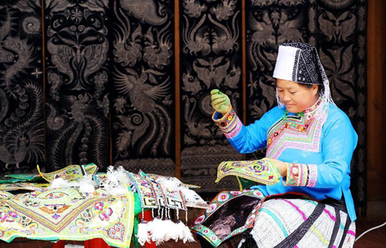 A woman of Miao ethnic group makes embroideries at her home in Zaiyong village, Tashi township, Rongjiang county, Qiandongnan Miao and Dong autonomous prefecture, southwest China’s Guizhou province, Nov. 11, 2021. (Photo by Li Changhua/People’s Daily Online)