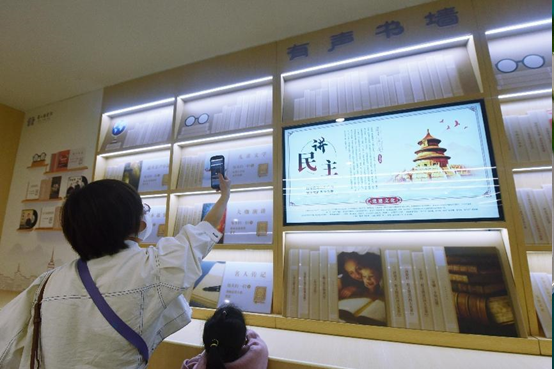 A citizen scans QR code with her mobile phone to enjoy multimedia books at a bookstore in Xiaoshan district, Hangzhou city, capital of east China’s Zhejiang province, April 20, 2022. (Photo by Long Wei/People’s Daily Online)