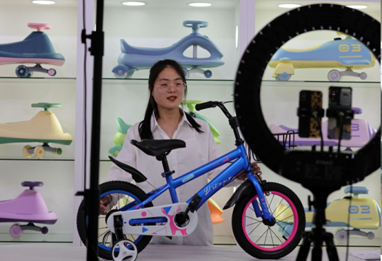 An employee with Hebei Tieniu Bicycle Industry Co., Ltd. based in Guangzong county, Xingtai city, north China’s Hebei province, sells bicycles for children via livestreaming during the 131st China Import and Export Fair, April 21, 2022. (Photo by Wang Lei/People’s Daily Online)