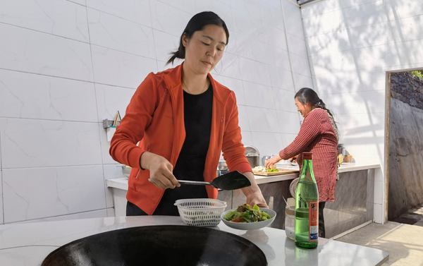 Villagers cook in a newly renovated kitchen in Chaoyang village, Zuolong township, Langao county, northwest China’s Shaanxi province. (Photo by Chen Yan’an)