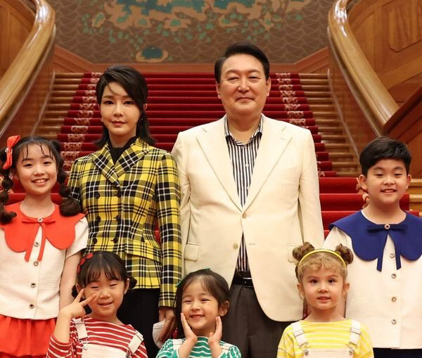 President Yoon Suk-yeol and first lady Kim Keon-hee take a commemorative photo with children on the steps of Cheong Wa Dae on May 22.