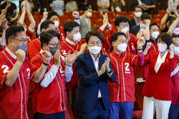 Lee Jun-seok (center in front row) chairman of the ruling People Power Party (PPP), claps with other key PPP members as the party is almost certain to win the local elections on June 2, 2022.