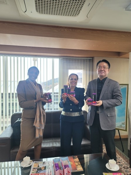 Amb. Mwende Mwinzi of Kenya (cetner) poses with CEO/Founder Lee Yang-soo of Goldrock Purple Korea (right) with the "Purple Ti" products in their hands.