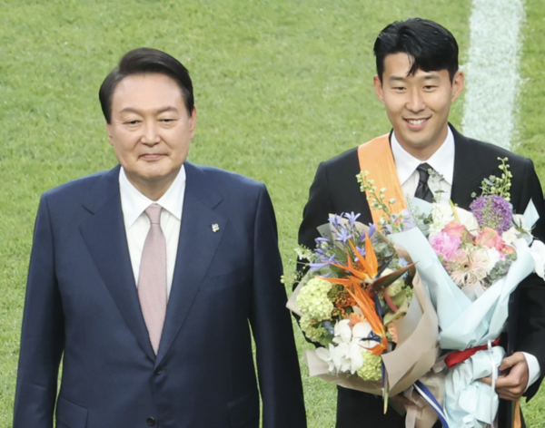 President Yoon Suk-yeol (left) is taking a commemorative photo with Son Heung-min after awarding him the Cheongnyong Medal, the highest Order of Sports Merit, at Seoul World Cup Stadium in Mapo-gu, Seoul on June 2.