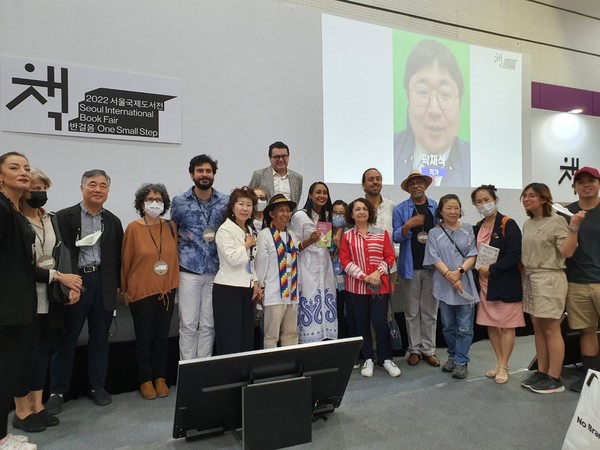 Minister of Culture Angelica Mayolo of Colombia (seventh from right, front row), Amb. Juan Carlos Caiza Rosero of Colombia in Seoul (center, the tallest in the back row), and Vice Chairperson Joy Cho of The Korea Post (ninth from right, front row) take a commemorative photo with visitors to a book fair commemorating the 60th anniversary of the establishment of diplomatic relations between Colombia and Korea.