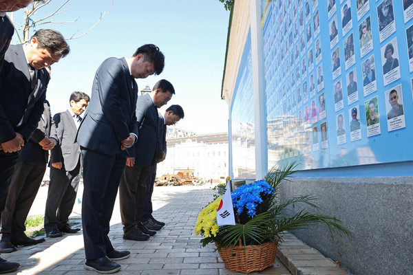 Chairman Lee Jun-seok (right, forefront) and the Korean delegates who visited Ukraine, pay their respects at the memorial wall in Kyiv on June 6, 2022.