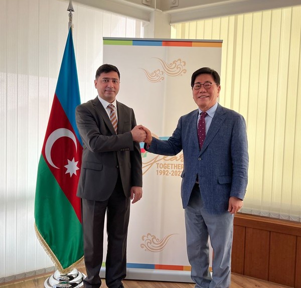 Economic-Commercial Counsellor Vasif Aliyev of Azerbaijan in Seoul (left) poses with Vice Chairman Song Na-ra of The Korea Post media against the backdrop of the insignia marking the 30th anniversary of diplomatic relations between Korea and Azerbaijan.
