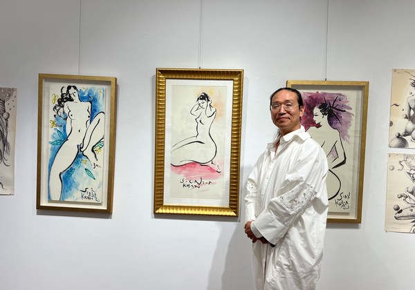 Artist Sion Khan poses for the camera in front of his nude drawings at an exhibition hall in Insa-dong, Jongno-gu, Seoul on June 8.
