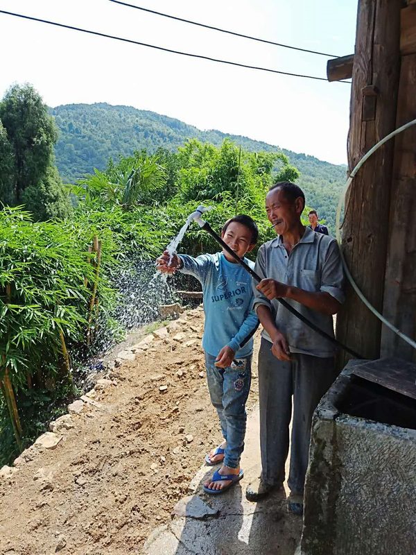 Photo taken on August 10, 2018 shows residents of Baihua village, Maoshi township, Huichuan district, Zunyi city, southwest China’s Guizhou province, testing water flow of water pipe. All the residents of Baihua village got access to safe and clean tap water in 2018. (Photo by Zhang Zhengju/People’s Daily Online)