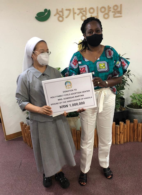 Madam Domingas Martins (right), spouse of the Ambassador of the Republic of Angola in Seoul, takes a commemorative photo with a director of the Holy Family Child Adoption Center after donating 1 million won to the center.