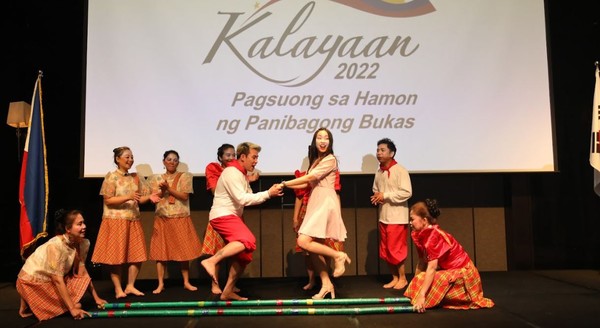 A Korean guest ventures on the stage to take part in the Tinikling Dancing of the Philippines