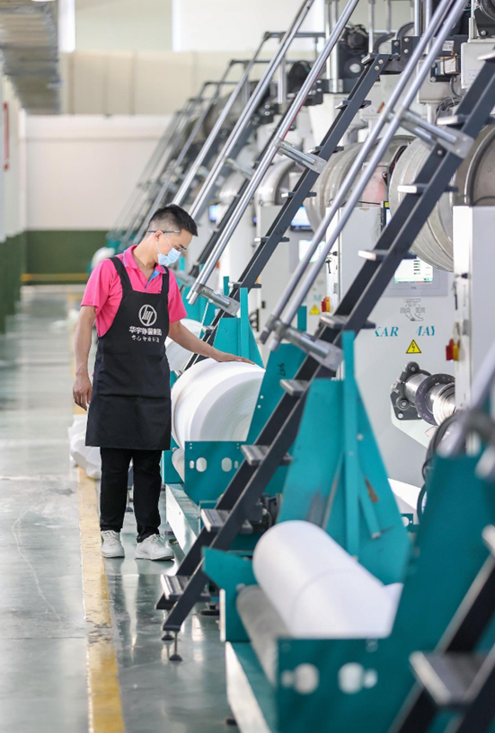 A worker checks weaving machines at a smart factory of a textile company in Jinjiang city, east China’s Fujian province, March 8, 2022. (Photo by Dong Yanjun/People’s Daily Online)