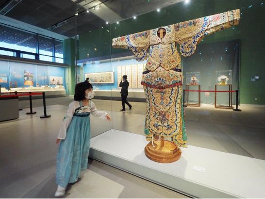 A girl in Hanfu, traditional clothing of China’s Han ethnic group, watches an exhibit in China Intangible Cultural Heritage Museum and China National Arts and Crafts Museum, June 2, 2022. (Photo by Du Jianpo/People’s Daily Online) 