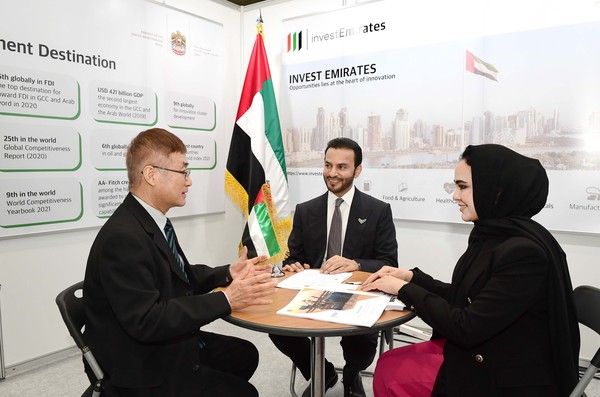  Ambassador Abdulla Saif Al Nuaimi of UAE (Center) is conducting a meeting with a visitor to the UAE booth.