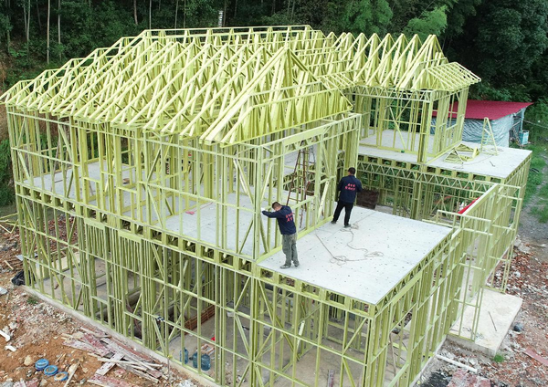 Construction workers build a prefabricated residential building with a lightweight steel structure in Chengpingqiao village, Shuangfeng county, Loudi city, central China’s Hunan province, August 17, 2021. (Photo by Nai Jihui/People’s Daily Online)