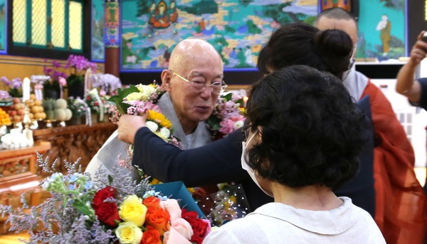 Chief Abbot Beopmyung (left) receives congratulatory flowers from believers. 