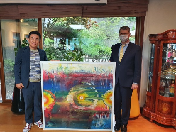 Artist Min Tae-hong (left) delivers an artwork titled the “2015 Creation of Heaven and Earth (120×120 Wood on Acrylic mix)” to commemorate the 30th anniversary of diplomatic relations between Korea and Ukraine and to pray for peace at the Ukrainian Embassy in Seoul.