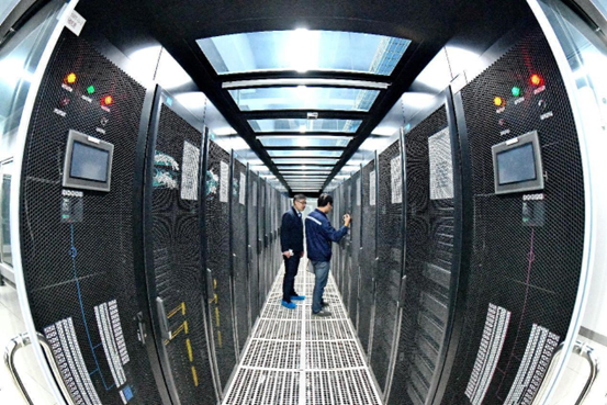Staff members of a data lake demonstration center in Rongjiang New Area, Ganzhou city, east China’s Jiangxi province, examine machine cabinets and data processing equipment, March 17, 2022. (Photo by Zhu Haipeng/People’s Daily Online)