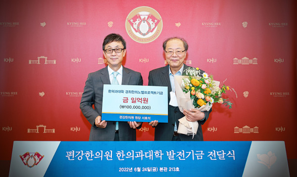 Director Seo Hyo-seok of Pyungkang Korean Medicine Hospital in Seoul (right) poses for the camera with President Hahn Kyun-tae of Kyung Hee University after donating 100 million won to the university on June 24.