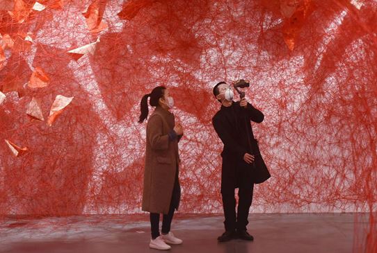 A curator displays via livestreaming works of art exhibited at the Hangzhou Triennial of Fiber Art in Zhejiang Art Museum in Hangzhou city, capital of east China’s Zhejiang province, March 14, 2020. (Photo by Long Wei/People’s Daily Online)