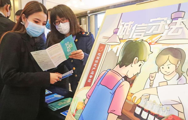 An officer from the intellectual property bureau of Haigang district, Qinhuangdao city, north China's Hebei province explains knowledge related to intellectual property to a merchant, April 20, 2022. (Photo by Cao Jianxiong/People's Daily Online)