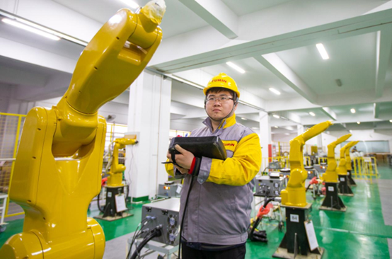 A worker tests industrial robots at a factory of a robot company at Hai’an economic and technological development zone, east China’s Jiangsu province, Jan. 5, 2022. (Photo by Zhai Huiyong/People’s Daily Online)