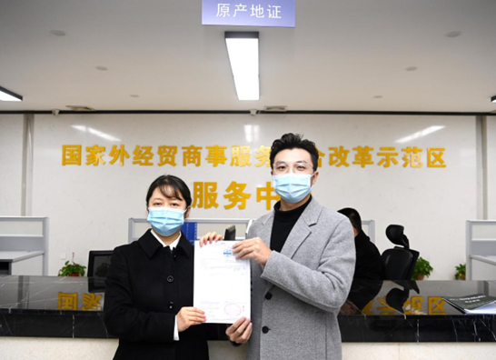 A representative of the Liuzhou branch of China Council for the Promotion of International Trade issues the first RCEP Certificate of Origin in Liuzhou, south China’s Guangxi Zhuang autonomous region, to a local company, Jan. 1, 2022. (People’s Daily/Li Hanchi)