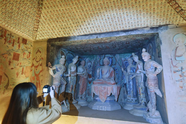 A visitor takes a photo of the Cave No.45 replica of the Mogao Grottoes in Dunhuang, northwest China's Gansu province, which is exhibited at the Zhejiang Art Museum, east China's Zhejiang province, April 17, 2022. The replica was made with 3D-print technology. (Photo by Long Wei/People's Daily Online)