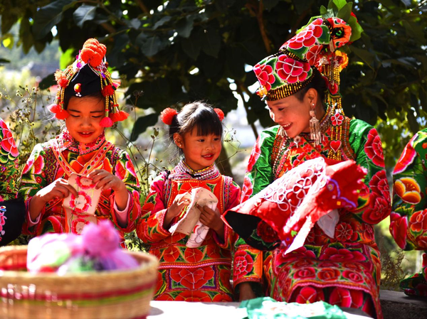 Girls from the Yi ethnic group make embroideries of Yi characteristics in Bijiada village, Dacang township, Weishan county, Dali Bai autonomous prefecture, southwest China's Yunnan province, Dec. 6, 2020. (Photo by Zhang Shulu/People's Daily Online)