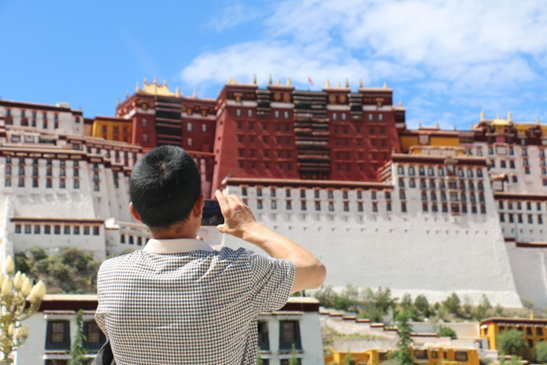 A tourist takes photos of the Potala Palace in Lhasa, southwest China’s Tibet autonomous region, July 2, 2020. (Photo by Wang Jianfeng/People’s Daily Online)