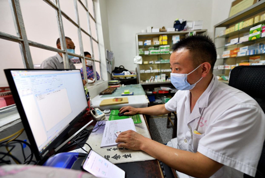 Doctor Wu Yun of a clinic in Tumen village, Chengguan township, Baokang county, Xiangyang, central China's Hubei province records information of villagers coming to the clinic to get medicines, Aug. 15, 2021. (Photo by Yang Tao/People's Daily Online)