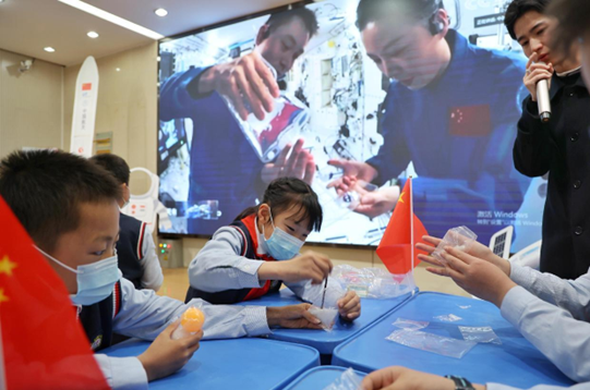 Elementary school students in Hefei, east China's Anhui province do scientific experiments while Chinese astronauts give a livestreamed popular-science lecture from China’s space station, March 23, 2022. (Photo by Chen Sanhu/People’s Daily Online)