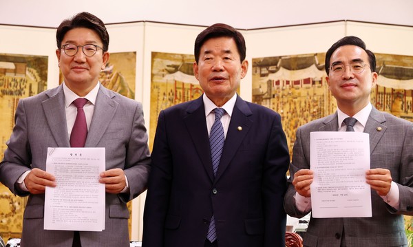 Rep. Kweon Seong-dong (left), acting chairman and floor leader of the People Power Party, Rep. Kim Jin-pyo (center), National Assembly Speaker, and Rep. Park Hong-keun, floor leader of the Democratic Party, pose for the camera at the National Assembly after reaching an agreement on parliamentary committee formation on July 22, 2022.