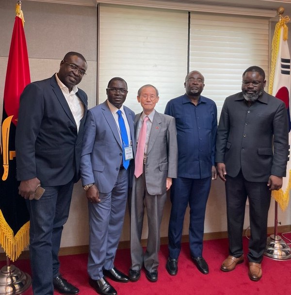 Director General Xiaquivulia of the Geological Institute of the Republic of Angola and Publisher-Chairman Lee Kyung-sik of The Korea Post pose with members of the Angolan delegation members.