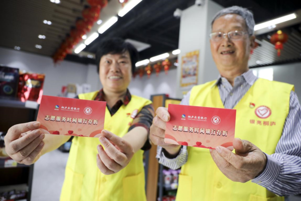 Two senior citizens in Tonglu county, Hangzhou, east China's Zhejiang province show their "bankbooks" of a time bank, May 31, 2021. (Photo by Xu Junyong/People's Daily Online)