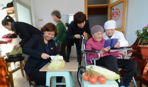 Volunteers from the Nanmen community, Jinzhou, northeast China's Liaoning Province provide services for Yuan Peizhi, a 103-year-old woman living alone, Feb. 27, 2018. (Photo by Li Tiecheng/People's Daily Online)