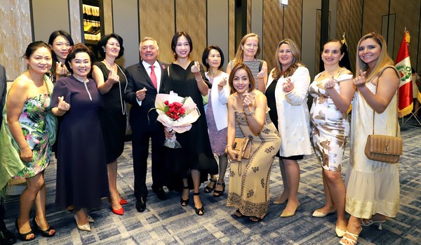 Ambassador Matute-Mejía of Peru (fifth from left) makes a ‘love sign with lady guests from Korea and many other countries of the world, mostly from the embassies in Seoul.