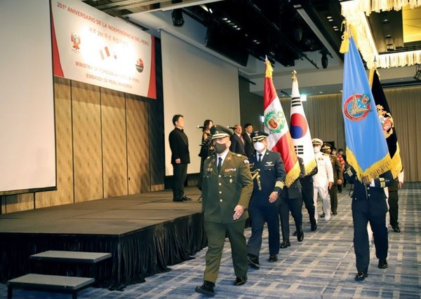 Honor Guards of Peru march with the flags of Peru and Korea.