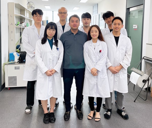 CEO Han Ki-soo of Neo Cremar (second from left in front row) poses with the company’s researchers at a laboratory.