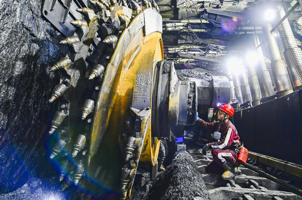 A worker repairs a mining machine in a mine shaft in Ejin Horo banner of Ordos, north China's Inner Mongolia autonomous region, Oct. 19, 2021. (Photo by Wang Zheng/People's Daily Online)