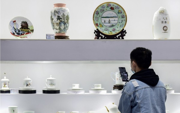 The China Jingdezhen International Ceramic Fair is held in Jingdezhen, east China's Jiangxi province, October 2020. Photo shows an employee of an e-commerce company hosting a livestream show at the event. (Photo by Hu Dunhuang/People's Daily)